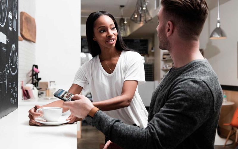 man and woman talking while sitting down at a cafe