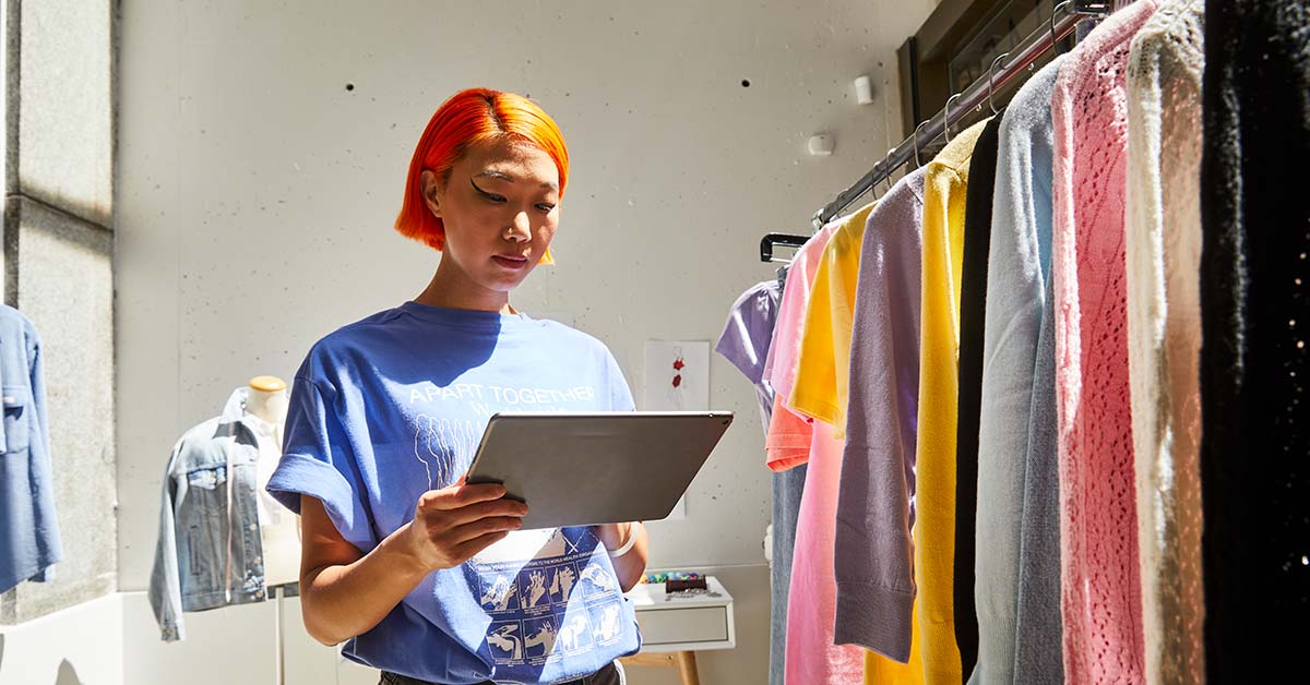 Perfect combinations of dress and bag! Beautiful young woman trying to  choose clothes to herself or customer while working in the fashion  boutique. Fashion stylist show new collection and in store Stock