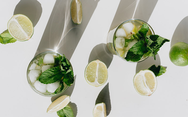 Top view of well drinks with lime and mint garnish