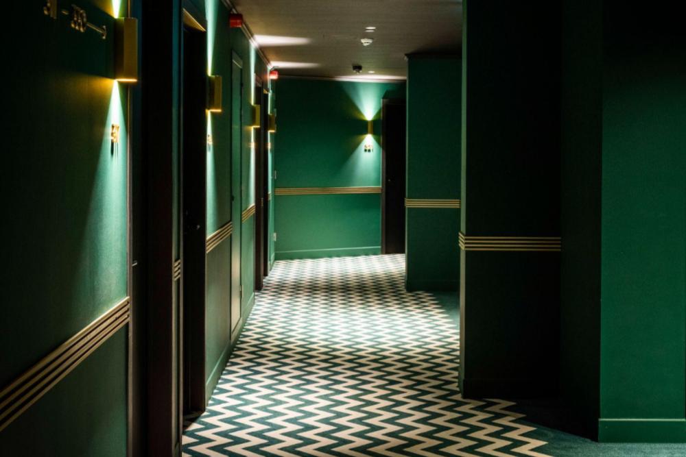 Interieur van YALO met groene muren en geruit tapijt