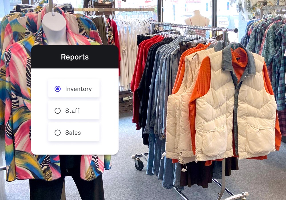 A retail clothing store interior with racks of colorful shirts, jackets, and denim. Overlaid on the image is a digital interface displaying a "Reports" menu with three options: Inventory, Staff, and Sales. The "Inventory" option is selected, indicating a focus on tracking stock levels within the store.