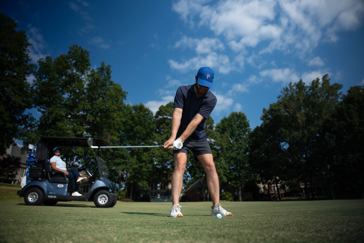 a player playing golf and a golf course.